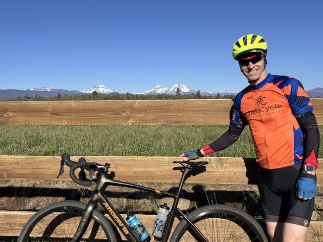 Charles standing with his gravel bike, mountains behind
