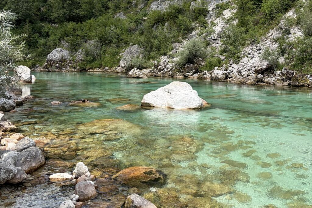 A white boulder in the emerald pools of the Soca river