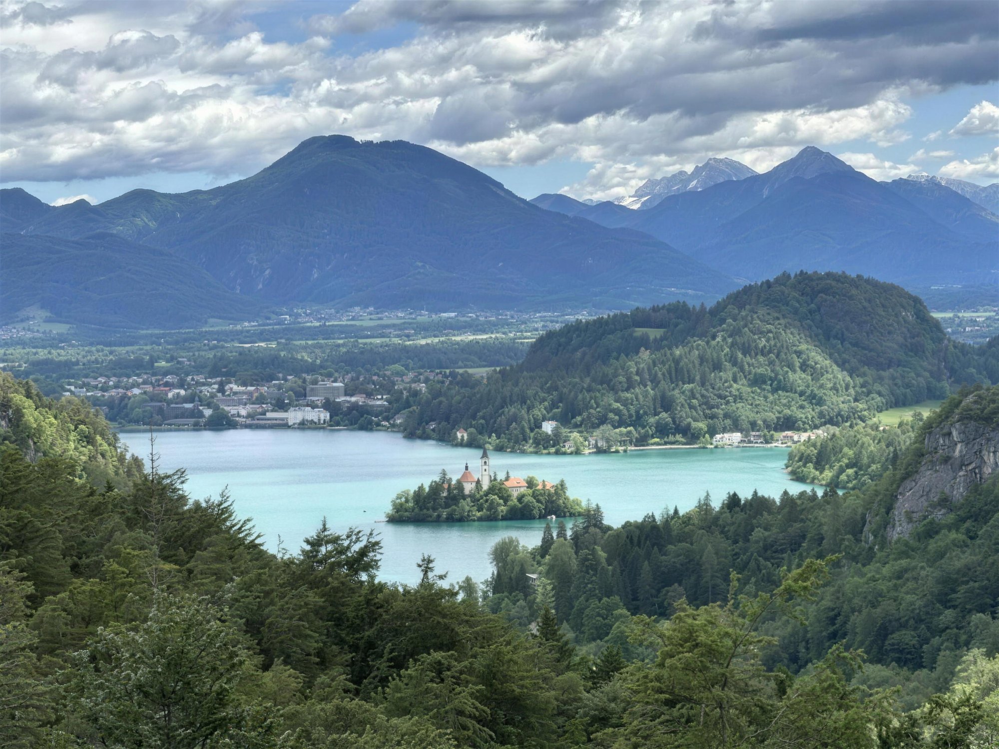 Lake Bled and its island church seen from the hills above, with the Karawanks behind