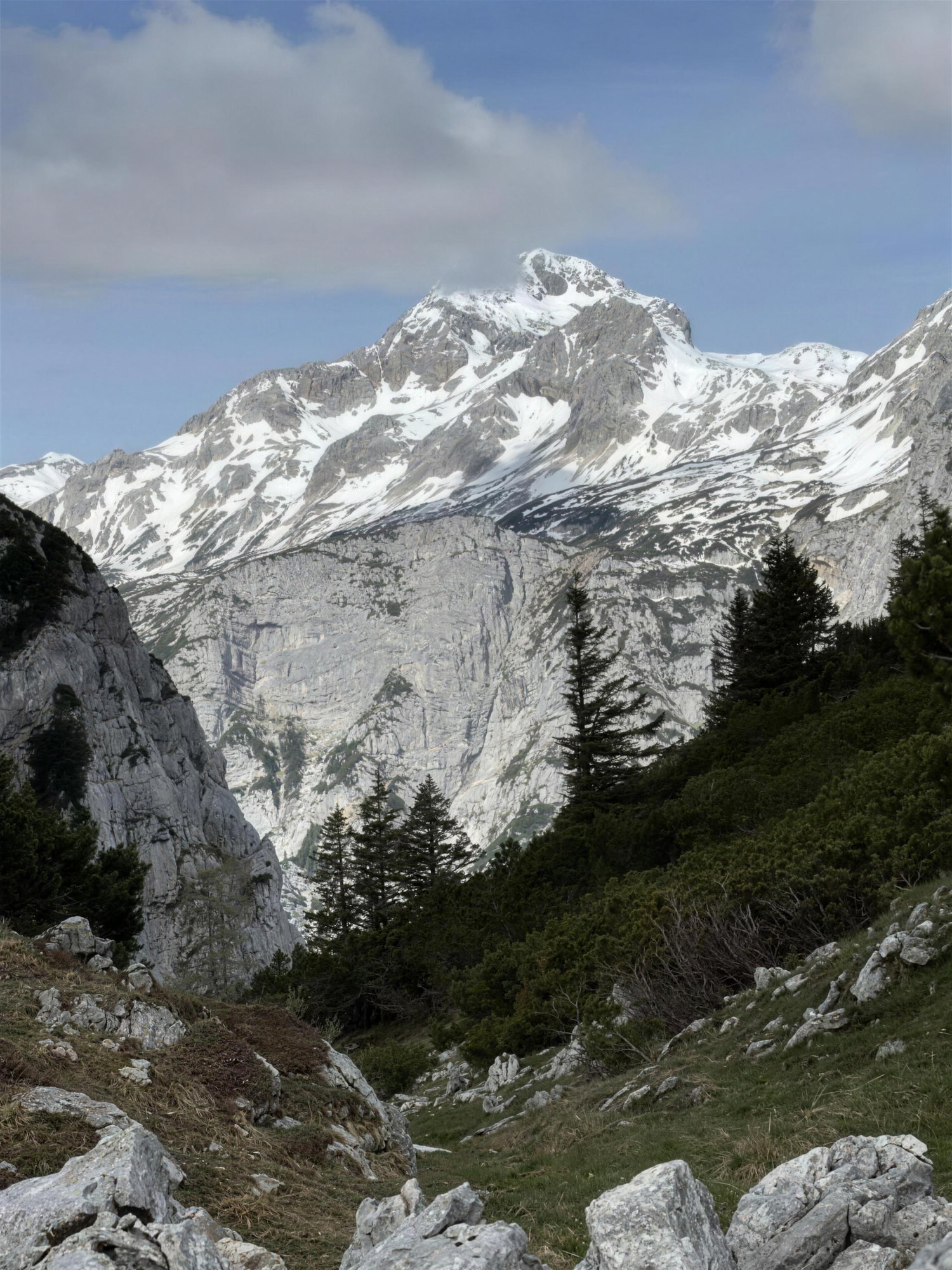 The snow-covered summit of Triglav, the highest peak in Slovenia, seen across the rocky foreground of the Julian Alps